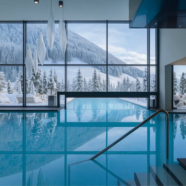 Poolbecken mit Zugang zum Aussenbecken und draussen sind die verschneiten Berge im Ahrntal
